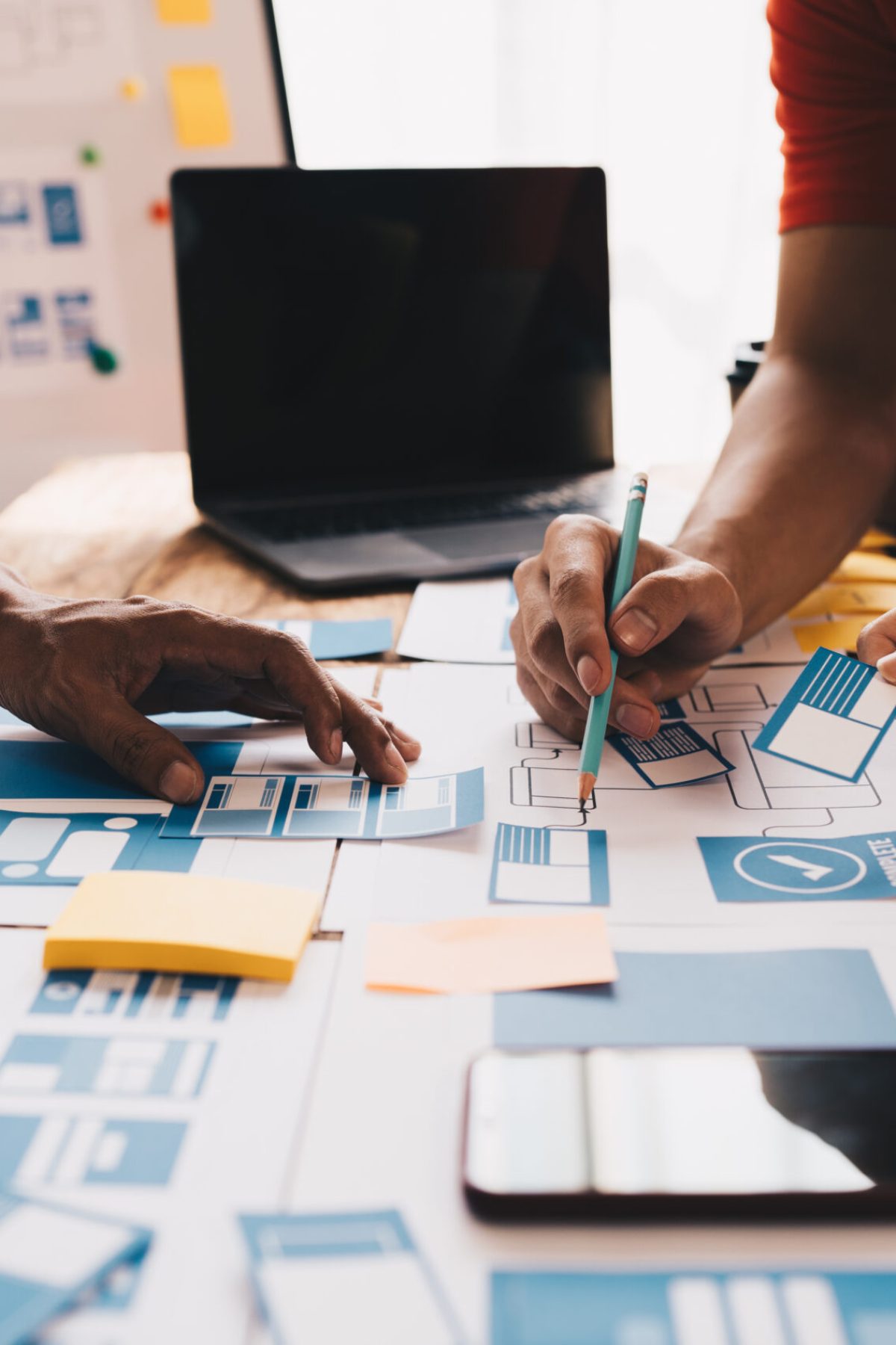 Ux developer and ui designer brainstorming about mobile app interface wireframe design on table with customer breif and color code at modern office.Creative digital development agency